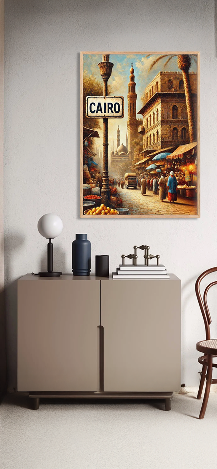 A cabinet with books and decor sits against a wall. Above it hangs a framed artwork depicting a lively Cairo street scene with historic buildings, market stalls, people, and a sign reading CAIRO.